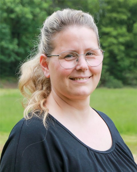 Porträt einer weiblichen Person, die in die Kamera lächelt