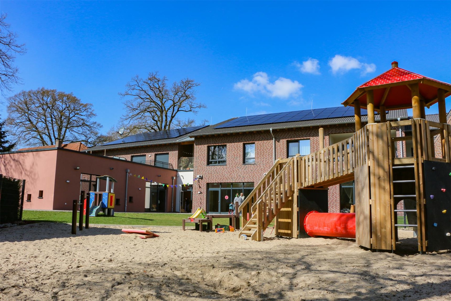 Außenansicht der Kita Heidezwerge Lüllingen mit Spielgeräten