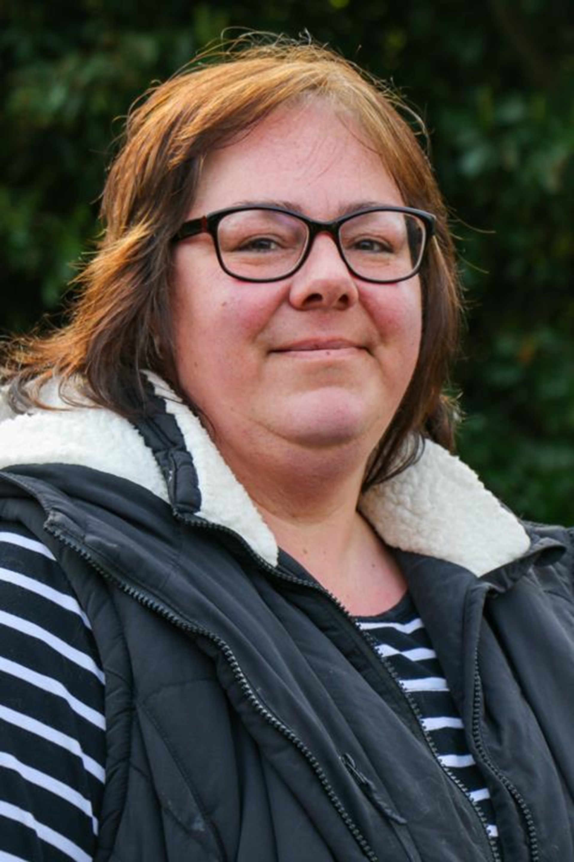 Porträt einer weiblichen Person, die in die Kamera lächelt