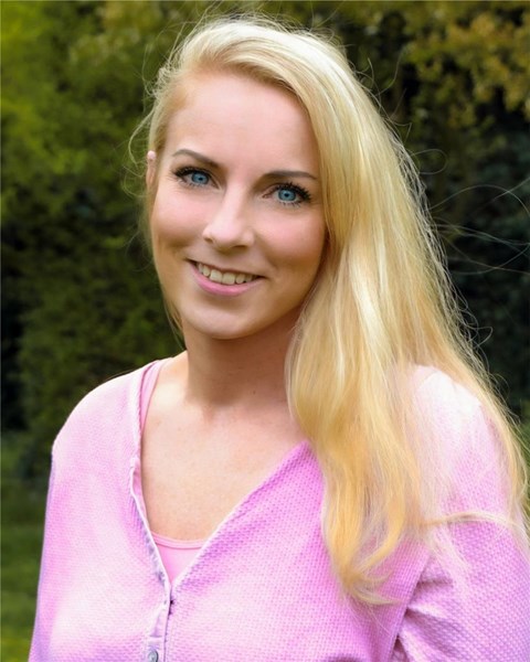 Porträt einer weiblichen Person, die in die Kamera lächelt