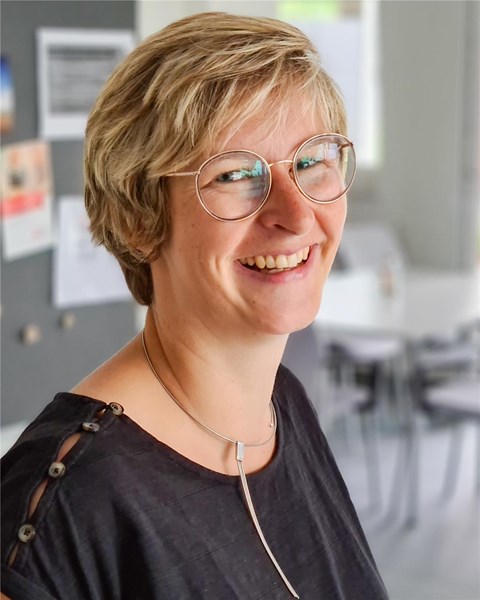 Porträt einer weiblichen Person, die in die Kamera lächelt