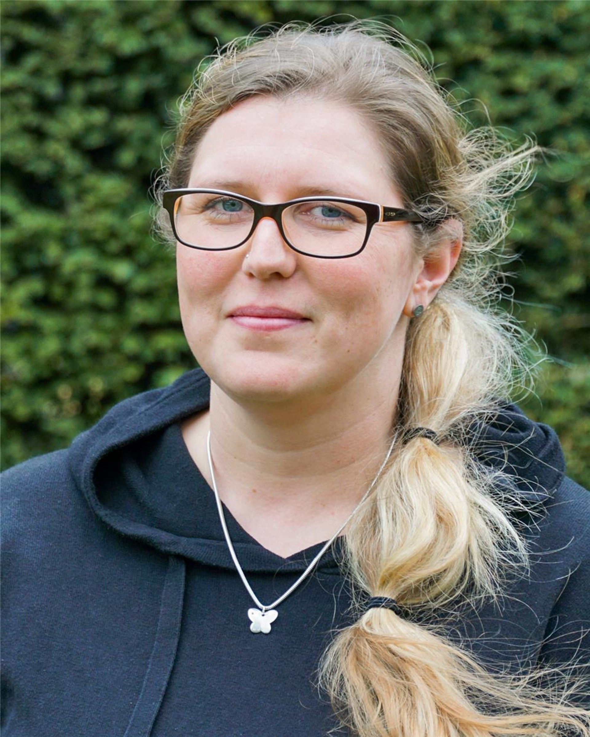 Eine weibliche Person, die in die Kamera lächelt