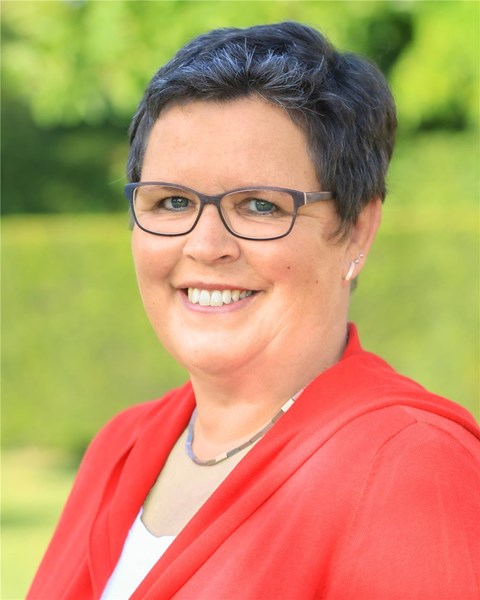 Porträt einer weiblichen Person, die in die Kamera lächelt