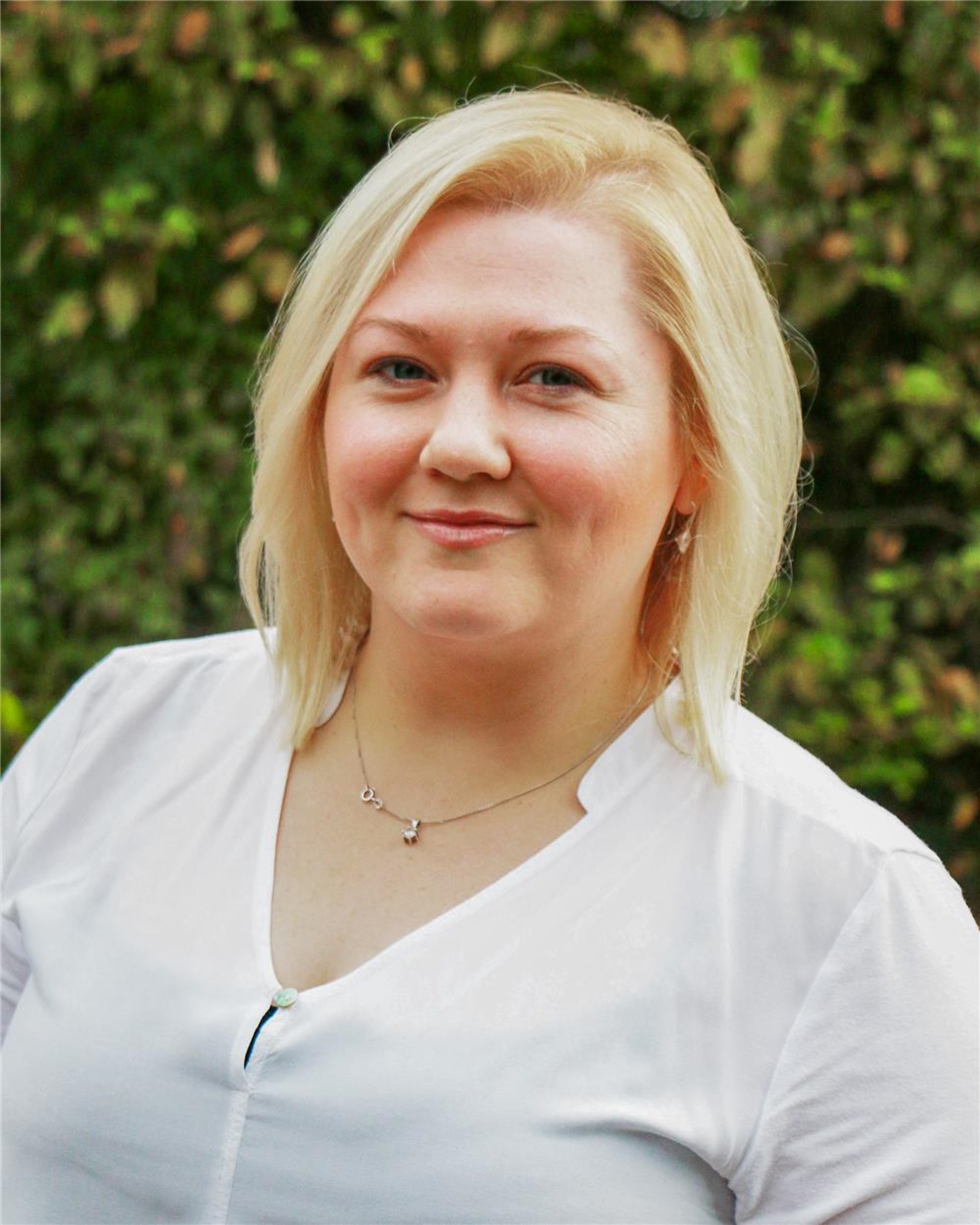 Porträt einer weiblichen Person, die in die Kamera lächelt