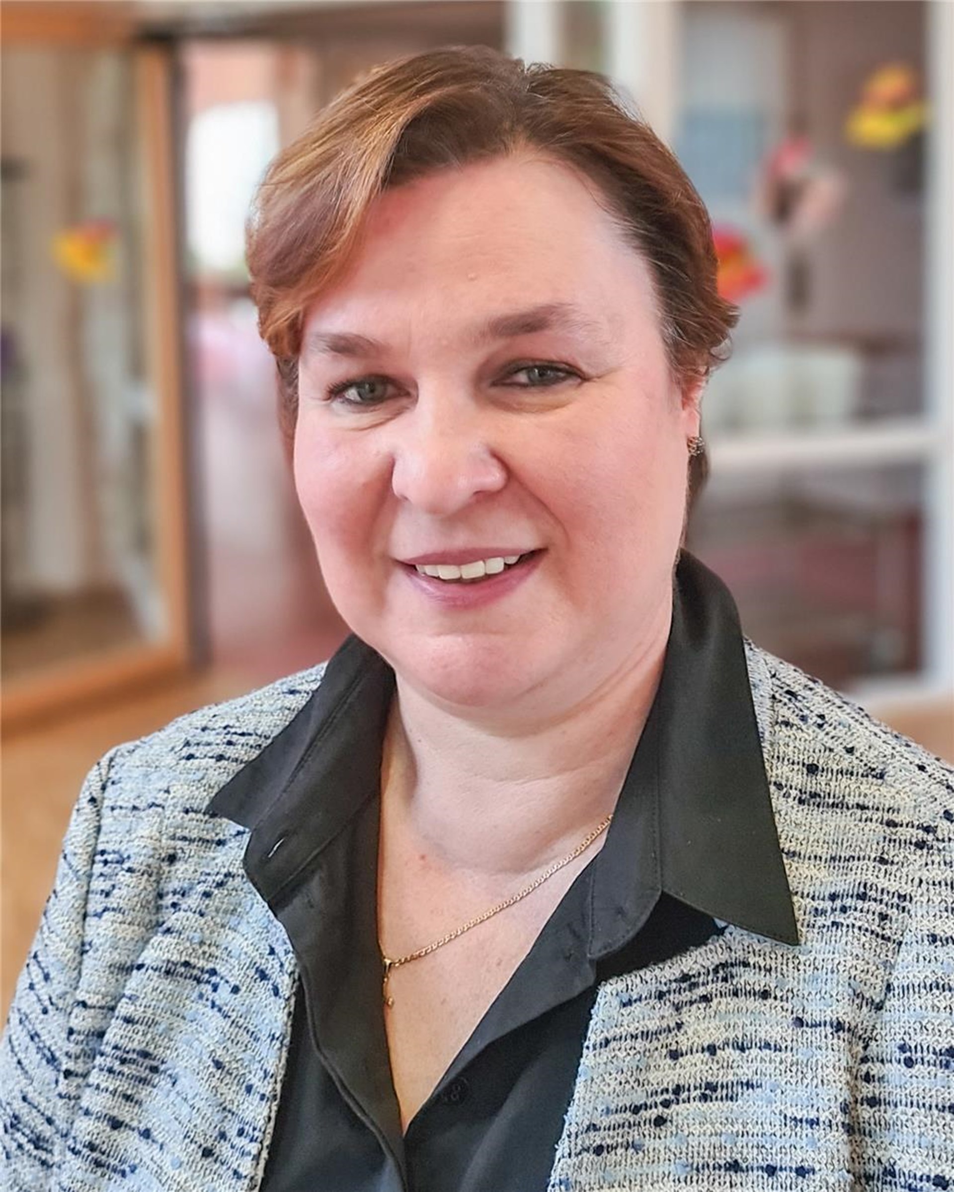 Porträt einer weiblichen Person, die in die Kamera lächelt